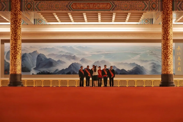 表彰会开始前，获奖代表们在北京人民大会堂三楼金色大厅里的《长江万里图》前合影。