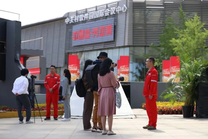 4月20日，在北京市海淀区中关村软件园主会场，2024年“中国梦·劳动美”庆祝“五一”国际劳动节心连心特别节目正在进行现场录制。在特别节目录制间隙，来自中国石油塔里木油田工程师文亮（右一）、刘金龙（左二）分别接受记者们的采访。